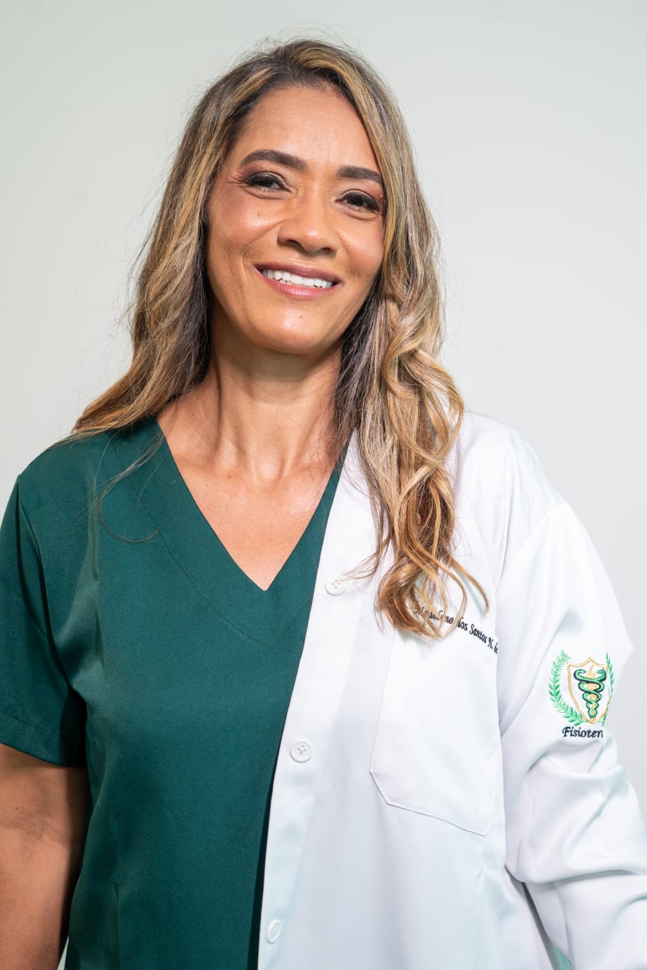 Madalena Souza usando jaleco branco sobre uniforme verde
